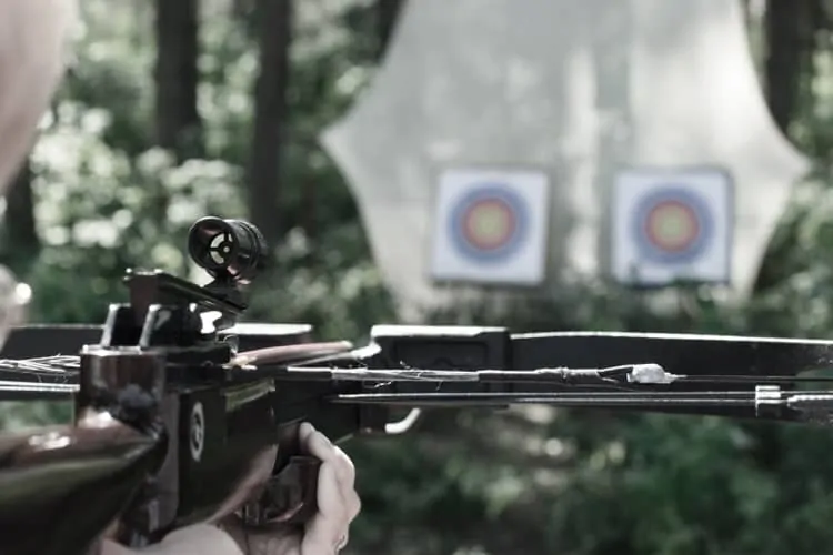 Schütze mit Armbrust beim Zielen auf eine Zielscheibe