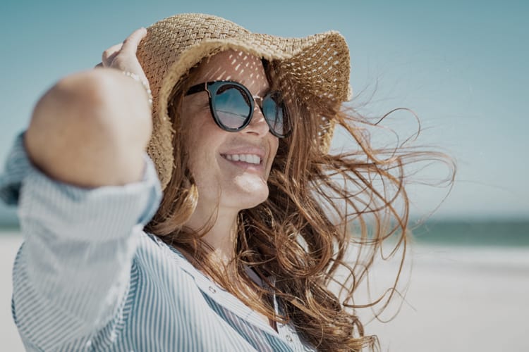 Frau mit optischer Sonnenbrille und Sonnenhut für den Schutz vor schädlichen Sonnenstrahlen